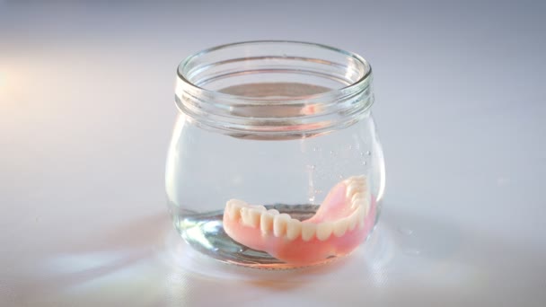 Elderly Woman Takes False Teeth Out Glass Water Dentures Glass — Vídeo de stock