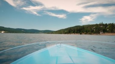 Board yacht on water. Regatta. Sailing yacht floating along mountain lake surrounded by green trees and hills. Sailing and travel concept. Summer vacation and holiday concept. Nature landscape