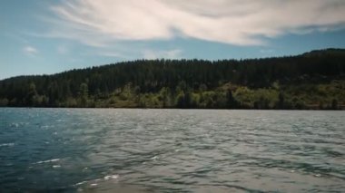 Peaceful mountain lake with calm water and green pine tree hills. Floating on lake with clear water. Blue mountain lake in nature landscape in Germany. Summer landscape on mountain lake