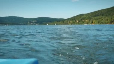 Boating on lake. Blue clear water on lake with green trees on background. Boat sailing on lake, back view of power water stream. amazing nature landscape