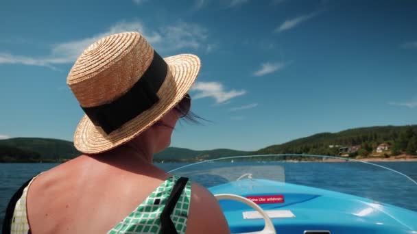 Back View Woman Straw Hat Steers Electric Boat Beautiful Mountain — Vídeo de stock