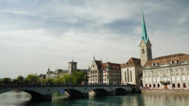 Zurich old town along Limmat river on sunny day in Switzerland. Fraumunster Church and beautiful river bank in Zurich. Popular summer travel destination. Zurich cityscape