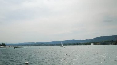 Zurich lake. Boats and yachts with tourists floating on lake in Zurich at summertime. Regatta on lake of Zurich. Summer vacation and tourism destination concept. Zurich city waterfront in Switzerland