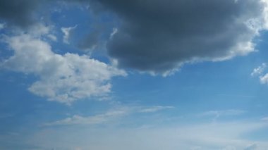 Cloudscape, timelapse. White clouds moving fast against sunny blue sky. Fluffy clouds on summer sky