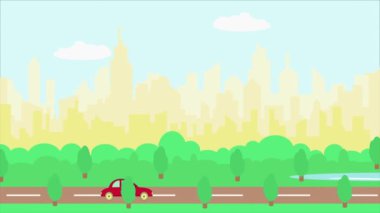 Red car driving on road against background of city and sunny blue sky