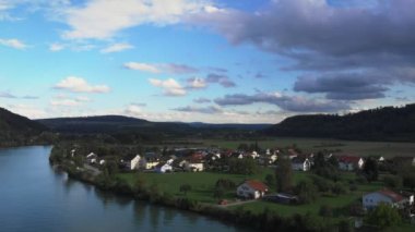 Mountain valley on riverbank with houses and cottages with green hills on background. Beautiful nature countryside landscape. Rhine river with houses along bank
