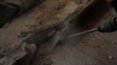 Matkap ucu yıkım alanındaki betonu kırıyor. İnşaat işçisi inşaat alanındaki beton duvarı delmek için çekiç matkabı kullanıyor. Evin restorasyonu. Konut geliştirme kavramı