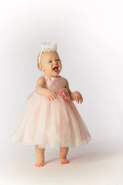 Una niña feliz con un vestido de fiesta rosa y sombrero se ríe —  Fotos de Stock