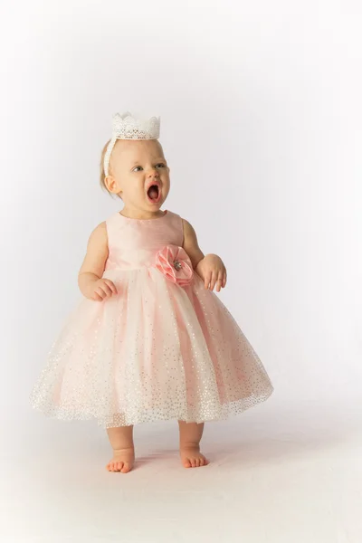 Ein wütendes Kleinkind mit Partykleid und Hut schreit lizenzfreie Stockfotos