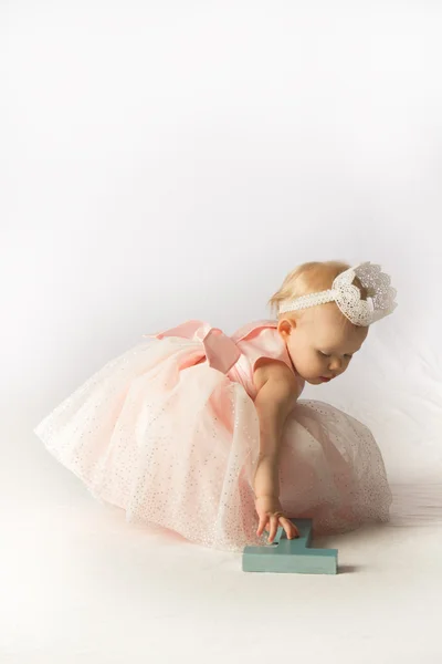 Ein kleines Mädchen im Geburtstagskleid mit Dekorationen Stockfoto