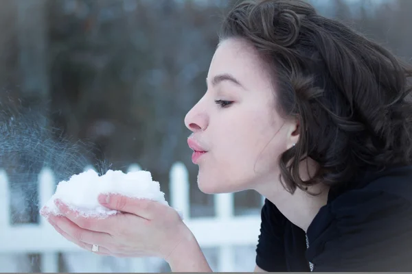 Uma jovem senhora sopra neve — Fotografia de Stock