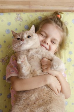 yerde bir döşek yatan kedi sarılma küçük kız