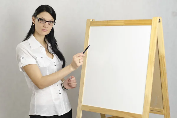 Businessgirl mit Brille zeigt Marker auf weißem Brett — Stockfoto