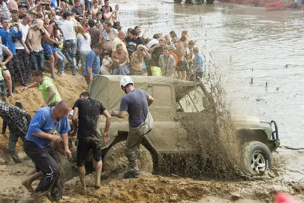 SUV stuck in the mud and the audience to help out — Stock Photo, Image