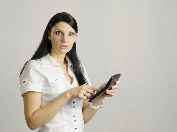 The girl is very upset by counting on the calculator — Stock Photo, Image