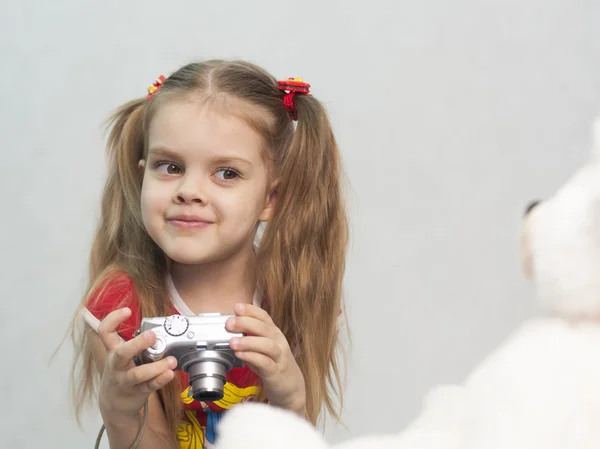 Meisje neemt foto van teddy digitale camera — Stockfoto