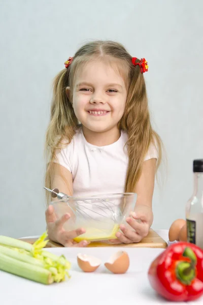 Cook karmaşası içinde oynayan kız bir cam kasede yumurta çırpma — Stok fotoğraf