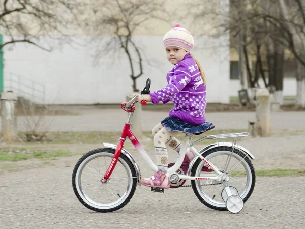 Una niña de cuatro años va en bicicleta — Foto de Stock