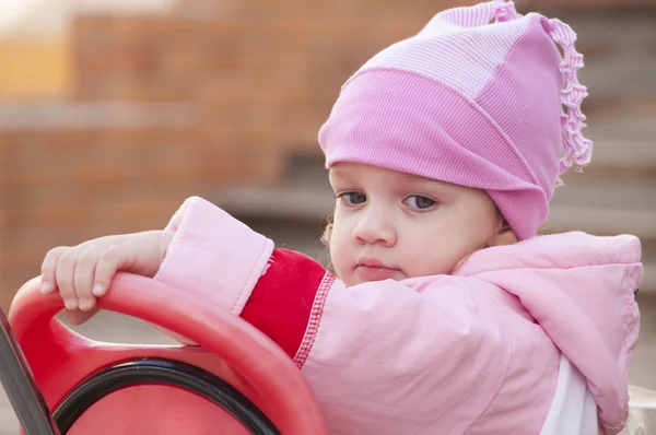 Two-year-old girl thoughtfully looks sitting on a bike — Stock Photo, Image