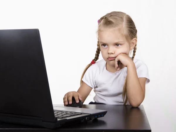 La chica sentada en la mesa y trabajando tranquilamente detrás del cuaderno — Foto de Stock