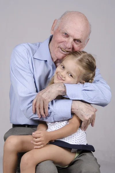 Портрет літнього чоловіка, який обіймає онуку — стокове фото