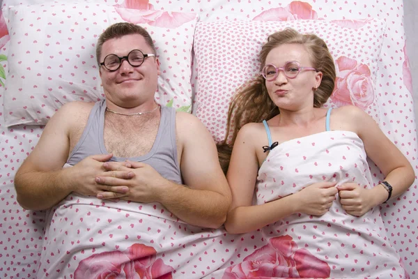 En ung par glasögon i sängen — Stockfoto