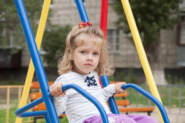 Dziewczyna jazda na huśtawce na placu zabaw — Zdjęcie stockowe