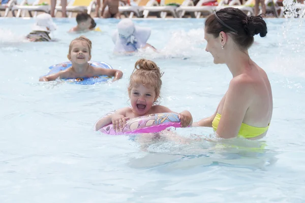 Uma mãe e duas filhas nadam em uma piscina pública — Fotografia de Stock