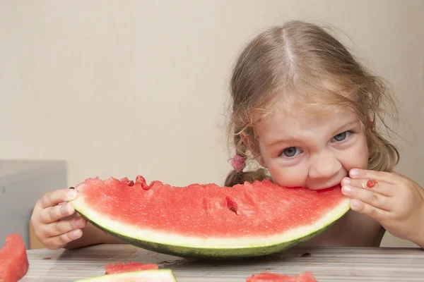 Menina de dois anos comendo melancia com rostos alegres — Fotografia de Stock