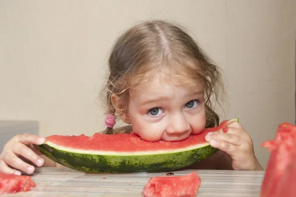 Niña de dos años comiendo sandía con caras alegres — Foto de Stock