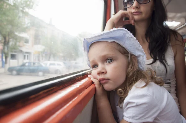 Chica triste y cansado mira a través de la ventana en el tranvía —  Fotos de Stock