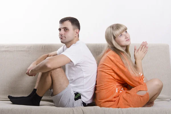 Casal sentado no sofá com as costas para o outro e sonhar — Fotografia de Stock