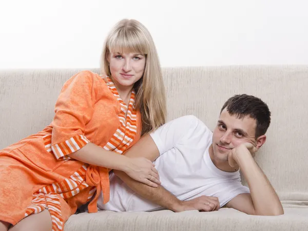 Ungt par liggande på soffan och tittar i ramen — Stockfoto