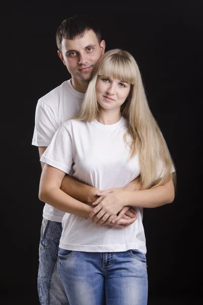 Portrait of a young couple on a black background — Stock Photo, Image