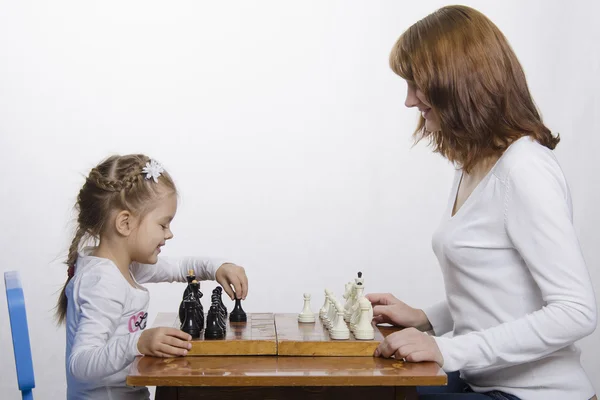 Мать учит дочь играть в шахматы — стоковое фото