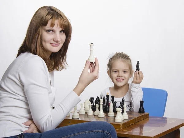 Mamma förklarar dotter syftet med schackpjäser — Stockfoto