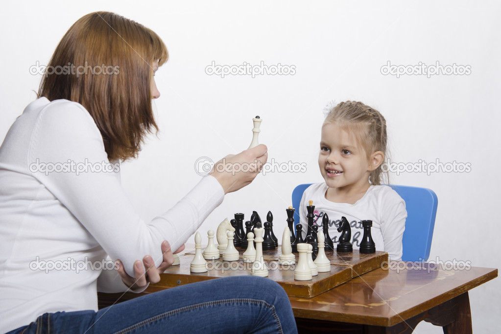 Mother explains daughter purpose of the chess pieces