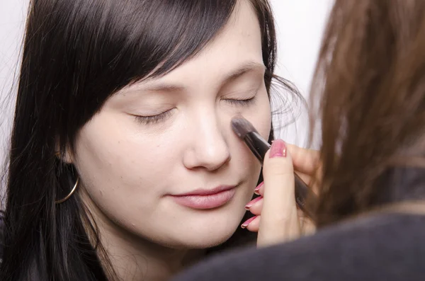 Maquillaje artista trata de polvo en el modelo de la cara — Foto de Stock