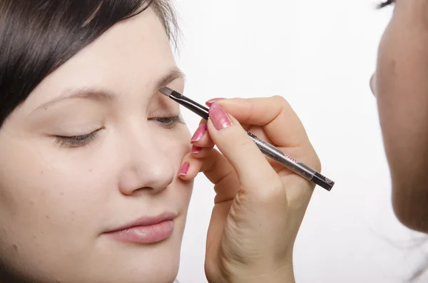 Maquillaje artista en el proceso de maquillaje trae modelo lápiz de cejas —  Fotos de Stock