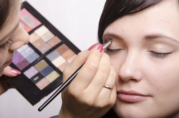 Makeup artist in the process of makeup colors upper eyelids model — Stock Photo, Image