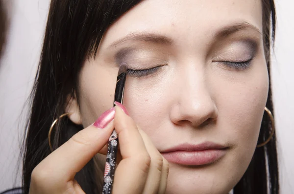 Makeup artist in the process of makeup colors upper eyelids model — Stock Photo, Image