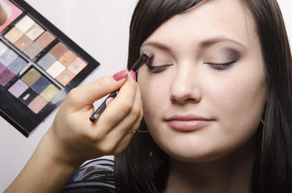 Makeup artist in the process of makeup colors upper eyelids model — Stock Photo, Image