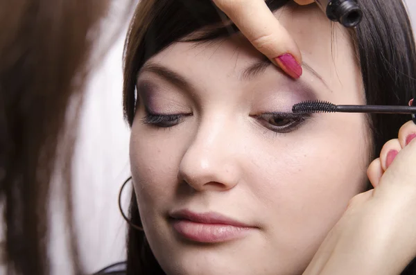 Макияж художник в процессе макияжа цвета ресниц модели — стоковое фото
