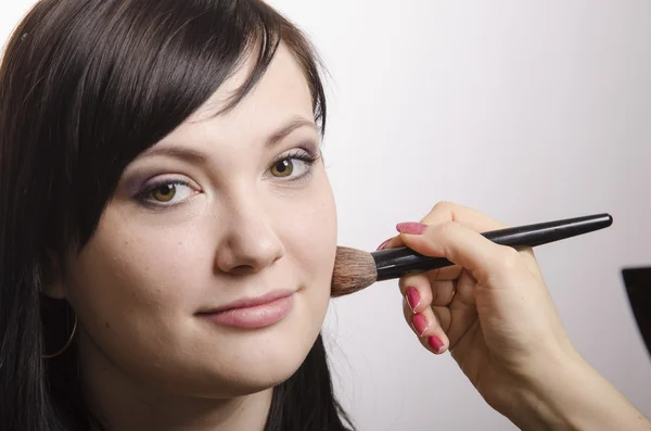Maquiagem artista lida com pó no modelo de rosto — Fotografia de Stock