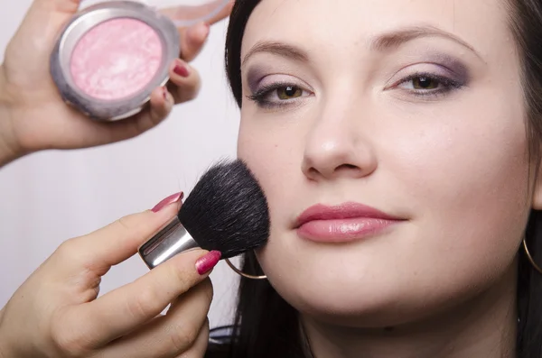 Makeup artist si occupa di polvere sul modello del viso — Foto Stock