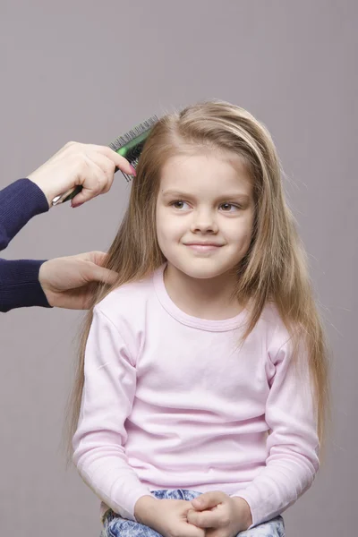 Fryzjer szczotkowanie jej długie włosy dziewcząt — Zdjęcie stockowe