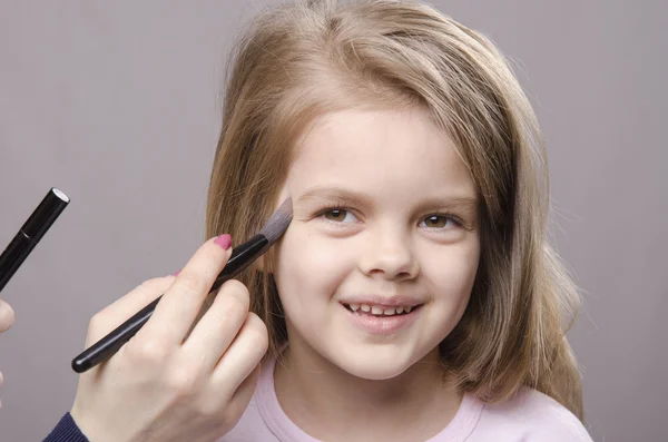 Makeup artist si occupa di polvere sul viso della ragazza — Foto Stock