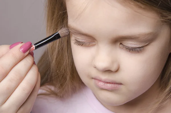 Maquillaje artista pinta los párpados en la cara de la chica — Foto de Stock