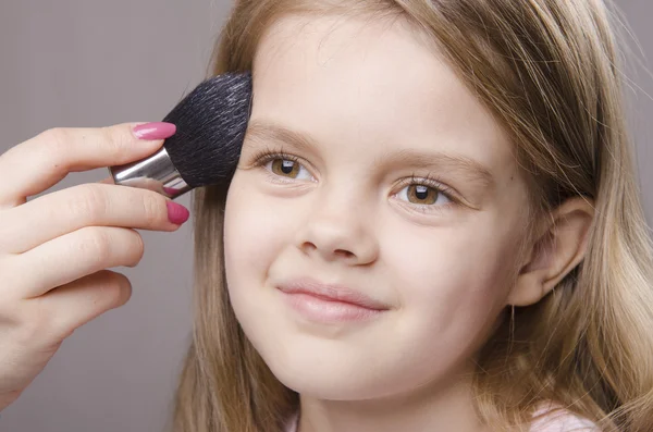 Makeupartist erbjudanden pulver på ansikte flicka — Stockfoto