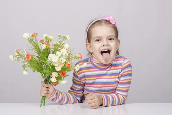 Ragazza con un mazzo di fiori seduta a tavola — Foto Stock